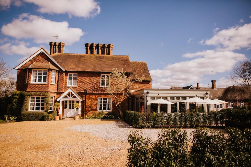 uma grande casa de tijolos com um jardim de Inverno em frente em The Farmhouse at Redcoats em Stevenage