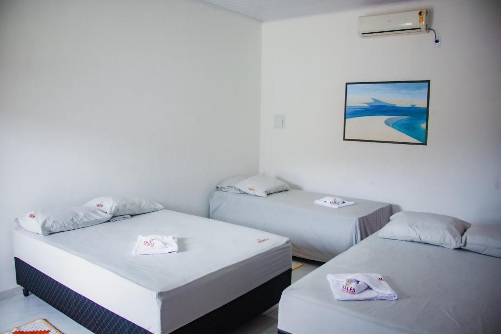 a room with two beds and a picture on the wall at Chalés Passagem do Canto in Barreirinhas