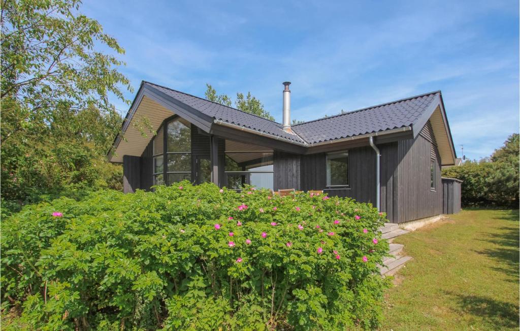 een zwart huis met een struik ervoor bij Stunning Home In Sams With House Sea View in Kolby Kås