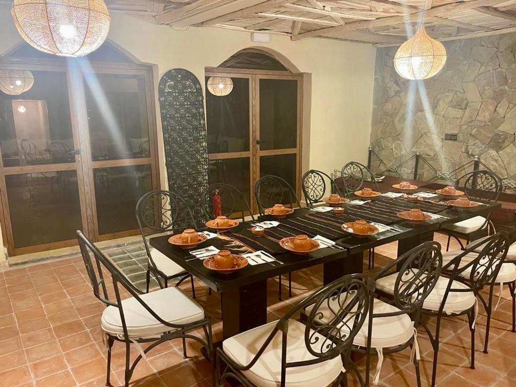 a dining room with a table and chairs with food on it at Chateau Imilchil in Imilchil