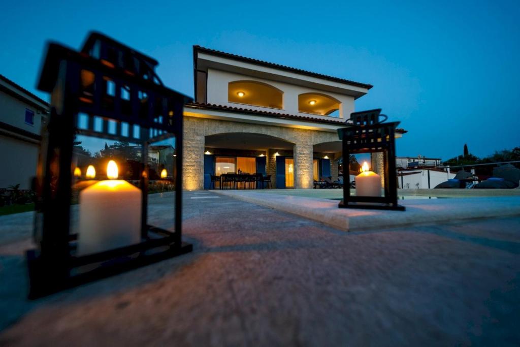 a building with two lit candles in front of it at Luxury Villa Loma 2 in Sveti Vid-Miholjice