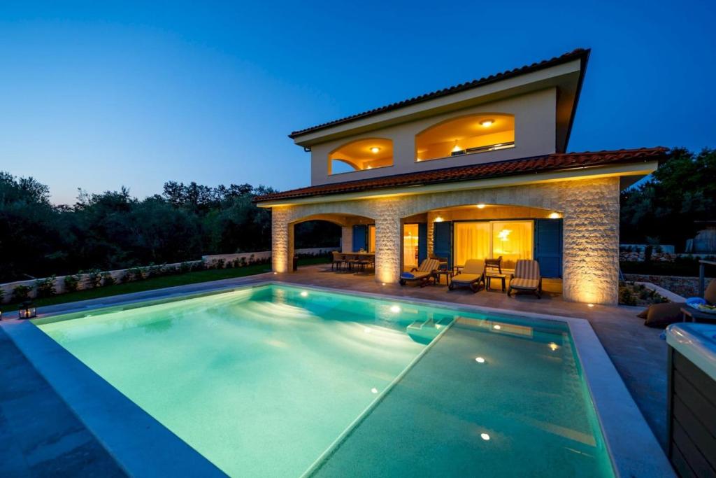 a house with a swimming pool in front of a house at Luxury Villa Loma 1 in Sveti Vid-Miholjice