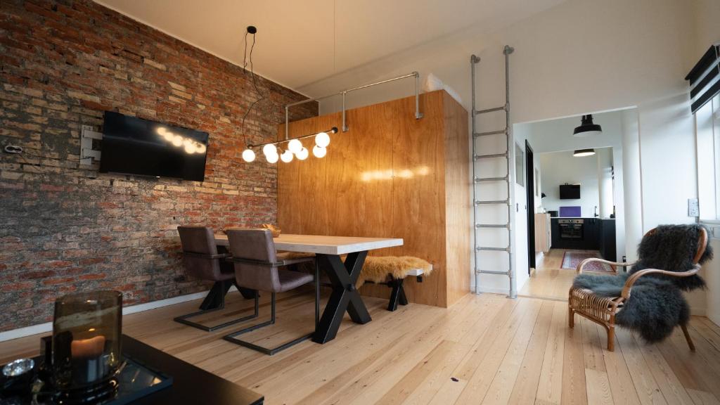 a dining room with a brick wall and a table and chairs at Broncks Apartment 5 in Tórshavn