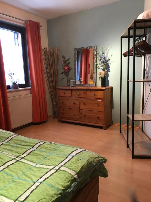 una camera da letto con cassettiera e cassettiera con specchio di Ferienwohnung Maxima a Weiskirchen