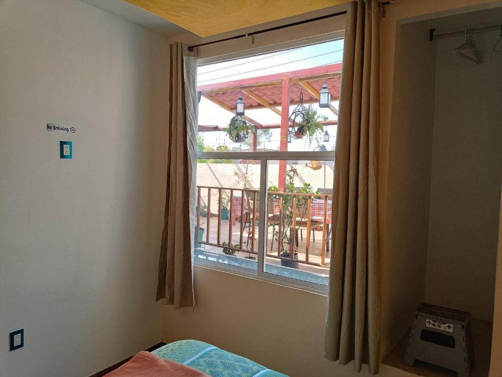 a bedroom with a window with a view of a balcony at PentHouse con Roof Garden Privado Aeropuerto CDMX in Mexico City