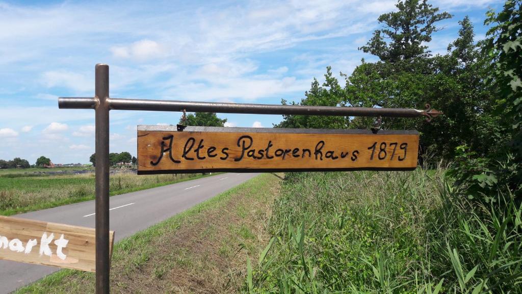 un panneau en bois sur le côté d'une route dans l'établissement Landhaus Ferienwohnung Wagner, à Weener