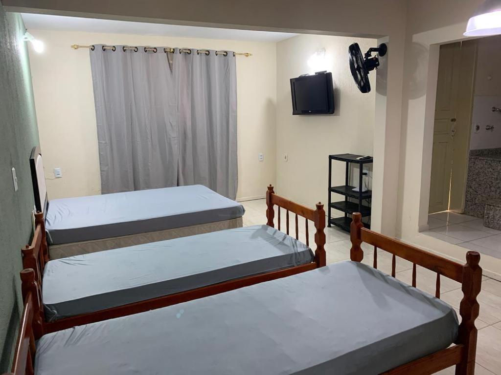 three bunk beds in a room with a television at Apartamento itapirubá in Imbituba