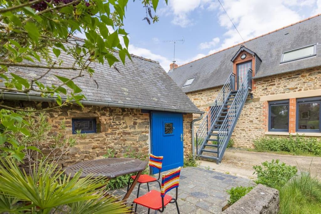 Ce cottage en briques dispose d'une porte bleue, d'une table et de chaises. dans l'établissement Le Tertre de la Nouette, 
