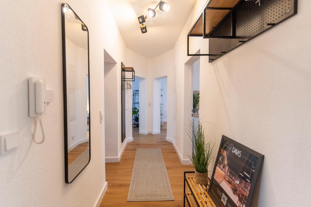 a hallway of a house with a mirror on the wall at DWELLSTAY - Wohnung 90qm, 3 Schlafzimmer, Küche, Wohnzimmer, Balkon, Netflix in Fulda