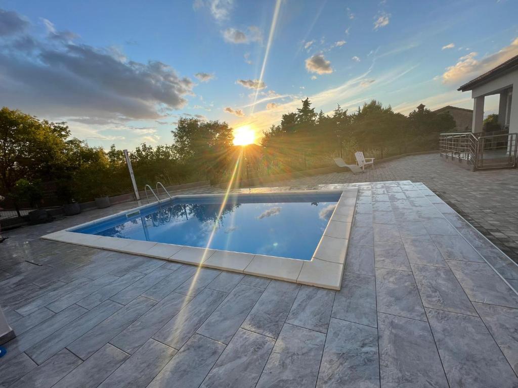 una piscina in un cortile con il tramonto di Holliday home Zion a Vrh