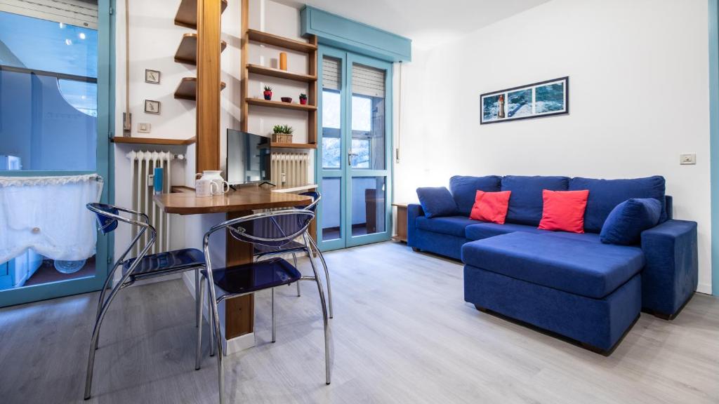 sala de estar con sofá azul y mesa en Via Leonardo Da Vinci 135 - Piano Terra, en Udine