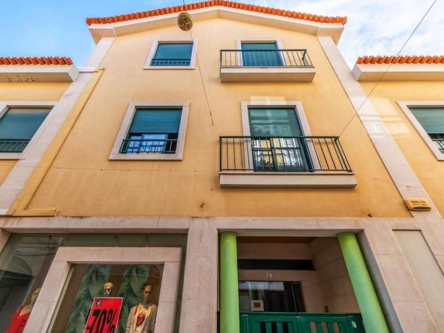 a yellow building with windows and balconies on it at Downtown Apartment (center) in Setúbal