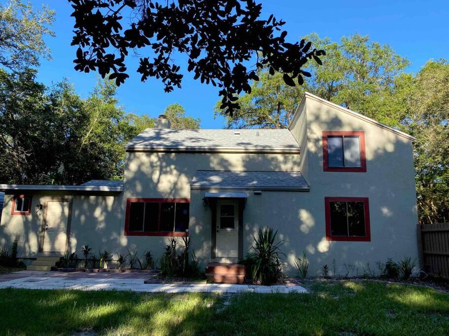 ein weißes Haus mit roten Fenstern und einem Hof in der Unterkunft Spacious and relaxing Home - Longwood, Florida in Orlando