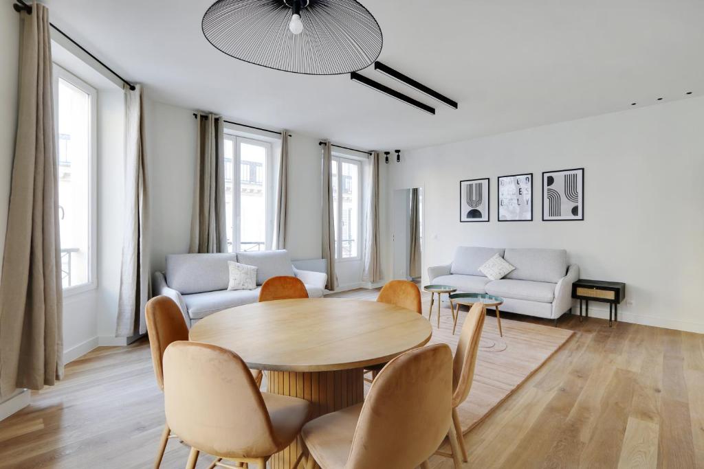 ein Wohnzimmer mit einem Tisch und Stühlen in der Unterkunft Pick A Flat's Apartments in Opéra - Rue d'Hauteville in Paris