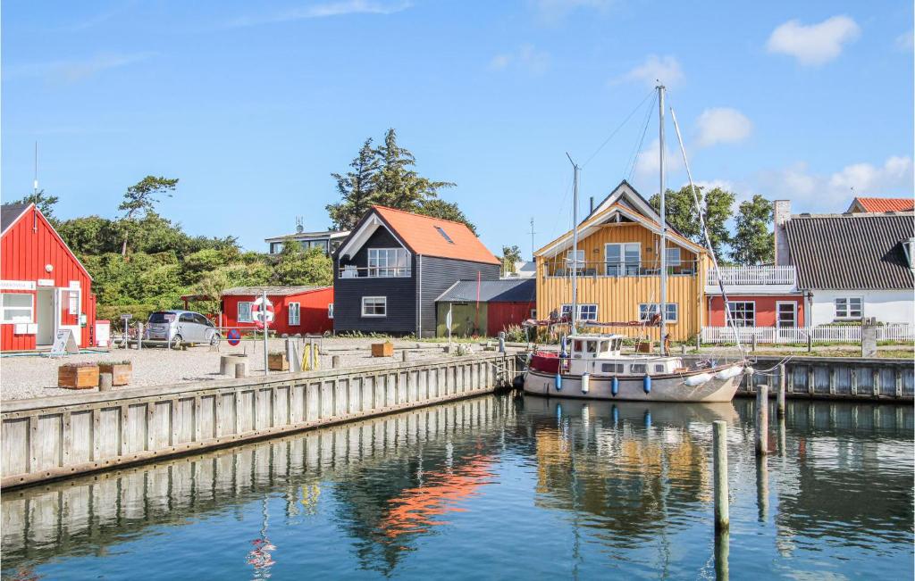 um barco está ancorado numa doca com casas em Lovely Home In Sams With Wifi em Nordby