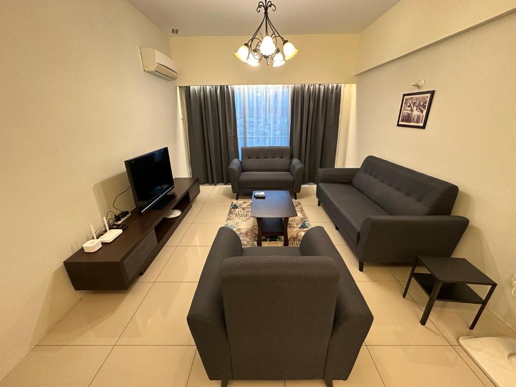 uma grande sala de estar com sofás e uma televisão em Kinta Riverfront by Mirath WiFi 500Mbps em Ipoh
