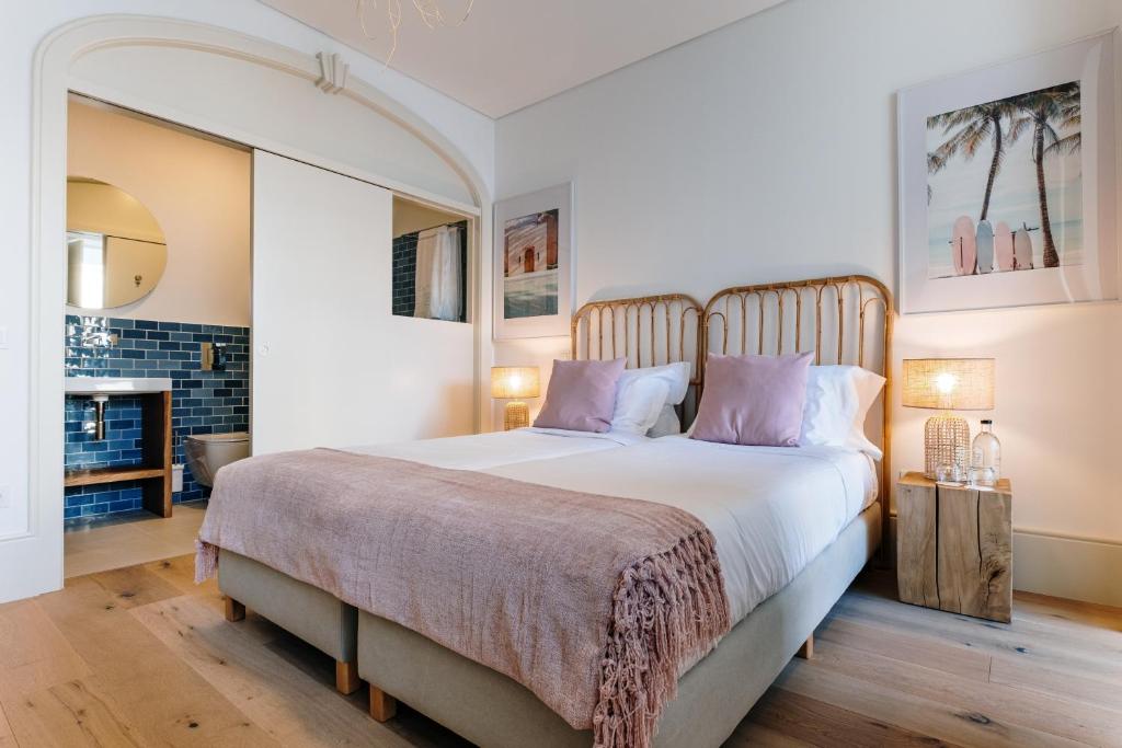 een slaapkamer met een groot bed met paarse kussens bij Ocean Porto - Beach House in Matosinhos