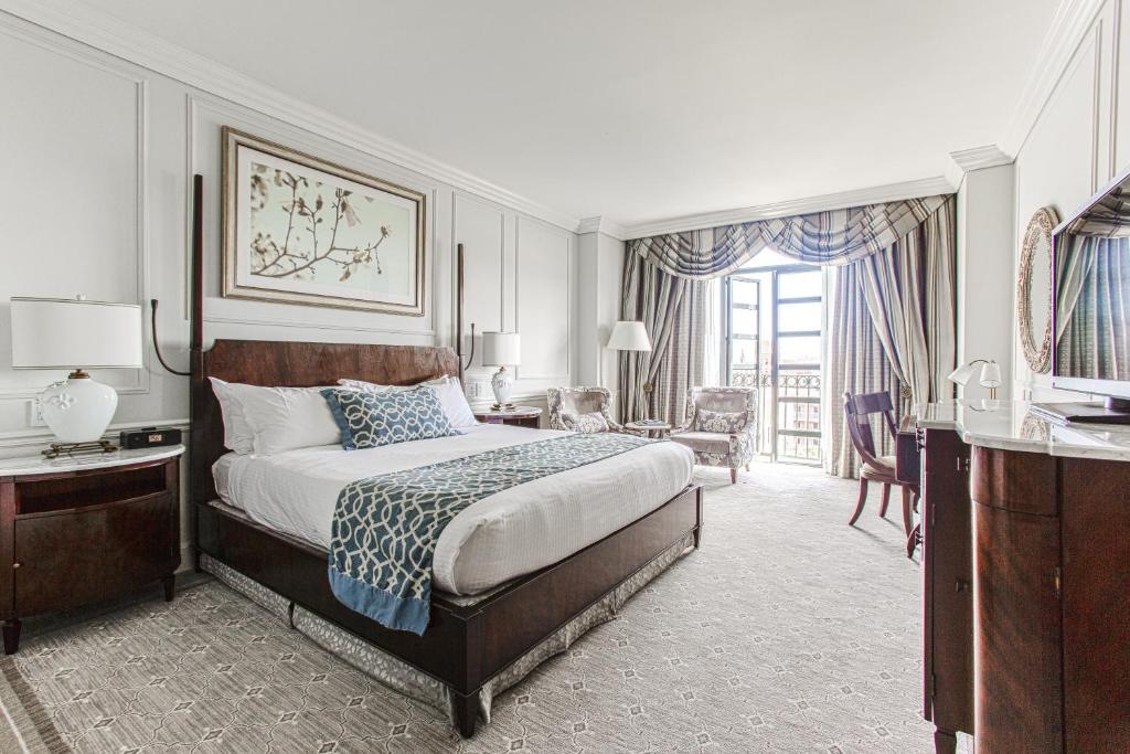 a bedroom with a king sized bed and a living room at The Charleston Place in Charleston