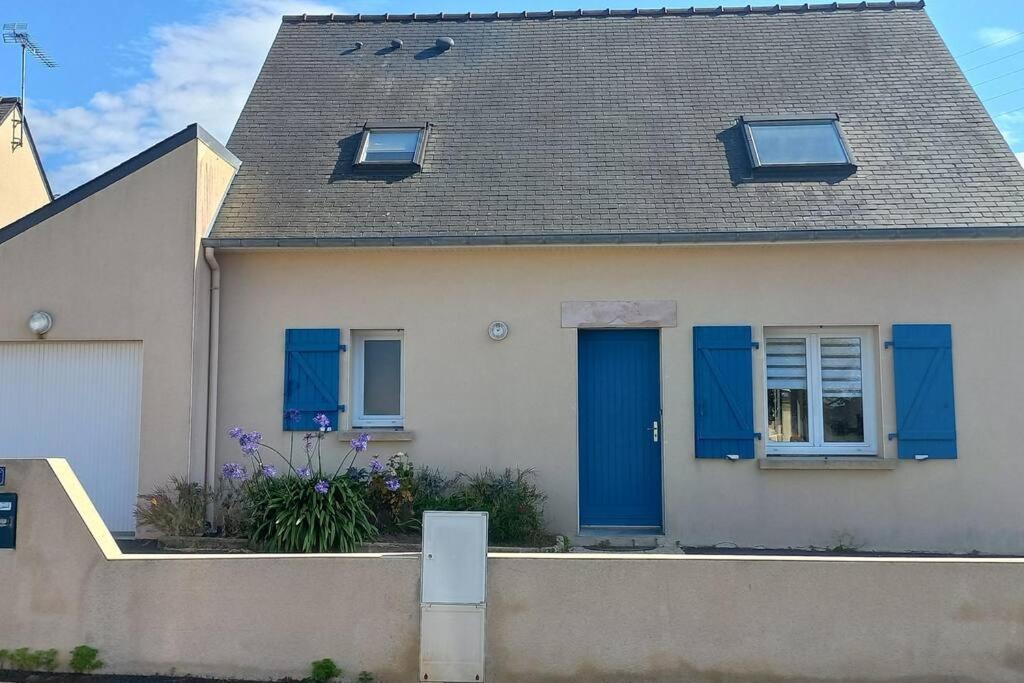 ein Haus mit blauen Fensterläden und einem Dach in der Unterkunft Maison de vacances à Erquy in Erquy
