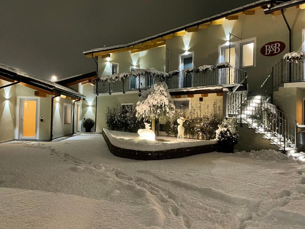 un patio cubierto de nieve frente a un edificio en AFFITTACAMERE VAL SUSA, en San Didero 