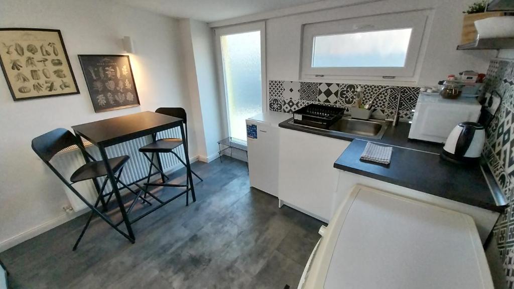 a small kitchen with a table and a counter top at Hi-Bp Garden City Batsanyi Tiny House near the city train with FREE PARKING in Budapest