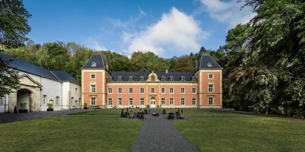 un gran edificio de ladrillo con un gran patio en Château du Pont d'Oye, en Habay-la-Neuve