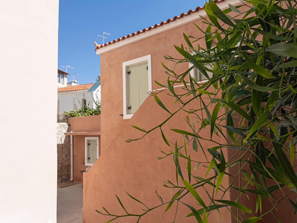 een roze gebouw met een raam en een plant bij Stasa Aegina in Aegina Town