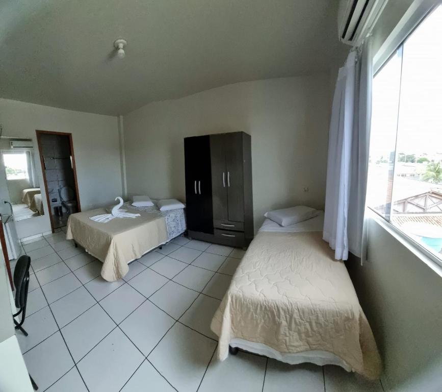 a bedroom with two beds and a large window at Hamara Soft Hotel 1 in Altamira
