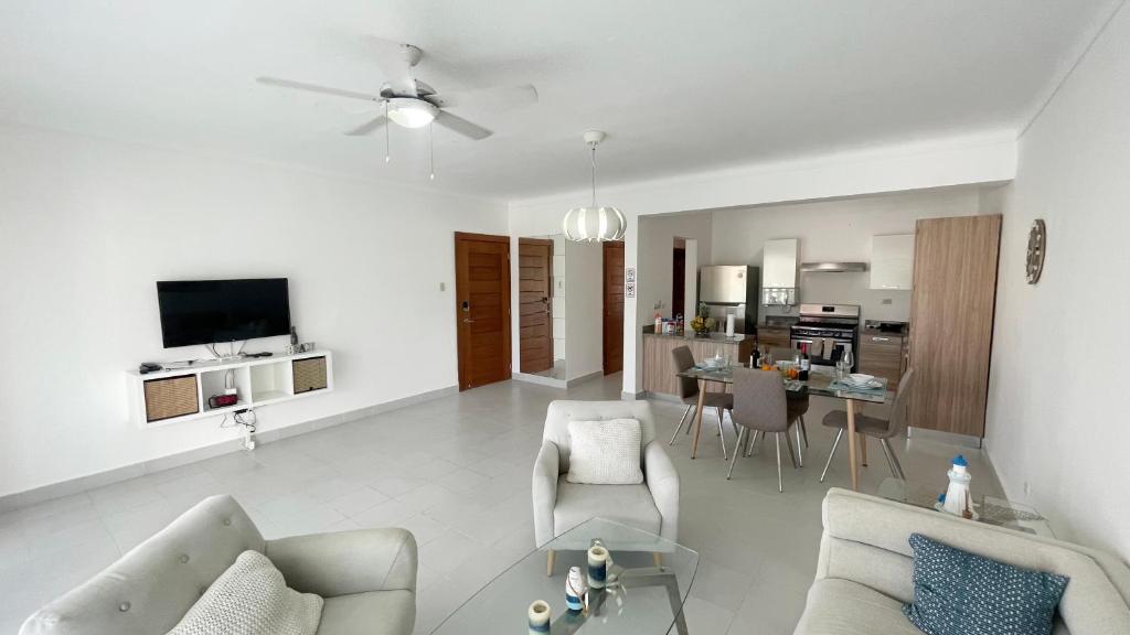 een woonkamer met een bank, stoelen en een tafel bij Precioso Apartamento a solo pasos de la Playa in Punta Cana