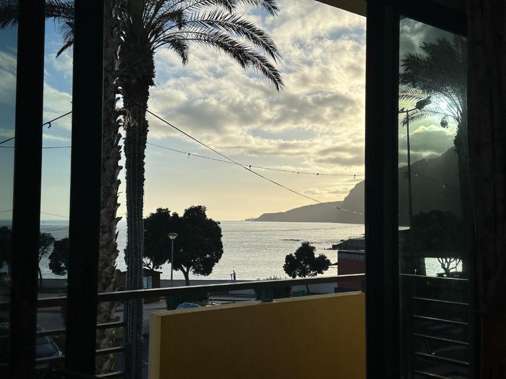 uma vista para o oceano a partir de uma janela do hotel em Apartamentos Amarelo em Caniçal