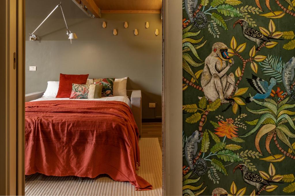 1 dormitorio con 1 cama y papel pintado con motivos florales en Appartamento luminoso a 5 min da Porta Nuova en Turín