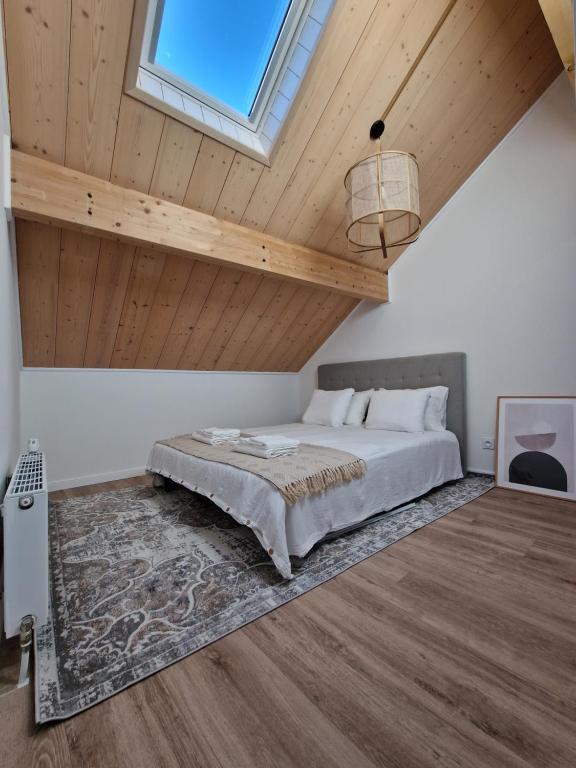 a bedroom with a bed and a wooden ceiling at Duplex type chalet dans le Jura in Morbier