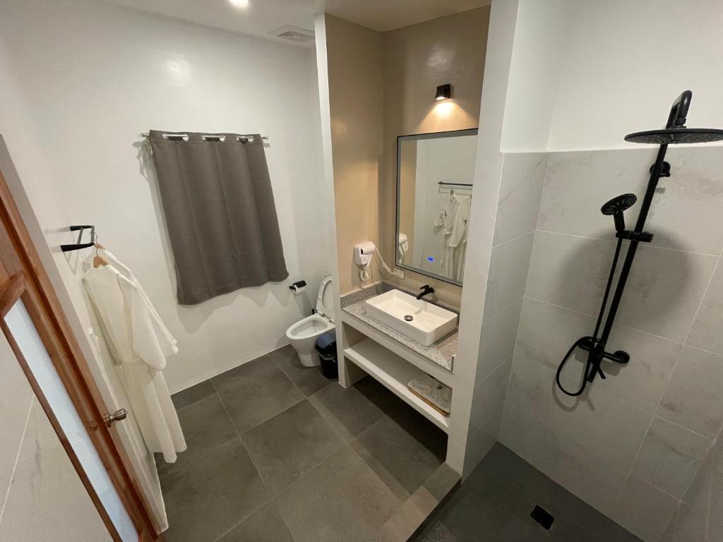 邦勞的住宿－Bathala Resort，一间带水槽、卫生间和镜子的浴室