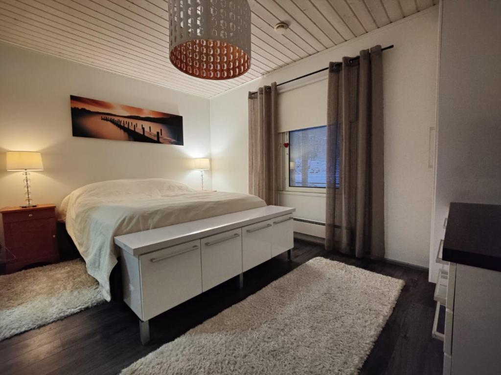 Habitación blanca con cama y ventana en VillaSki, en Rovaniemi