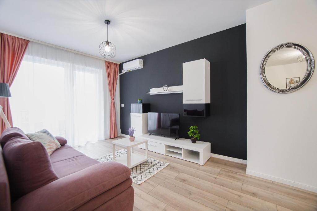 a living room with a couch and a mirror at Duet Noir in Oradea