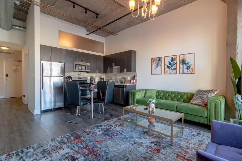 a living room with a green couch and a kitchen at McCormick Place Skyline view 2br-2ba with Optional parking for 6 guests in Chicago