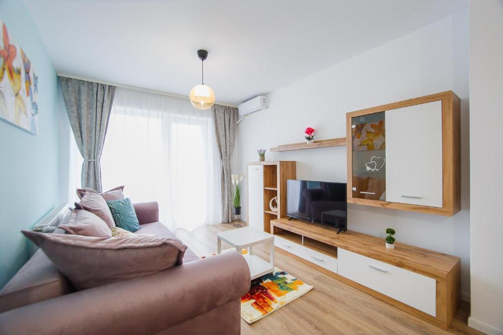 un salon avec un canapé et une télévision à écran plat dans l'établissement Duet Blanc, à Oradea
