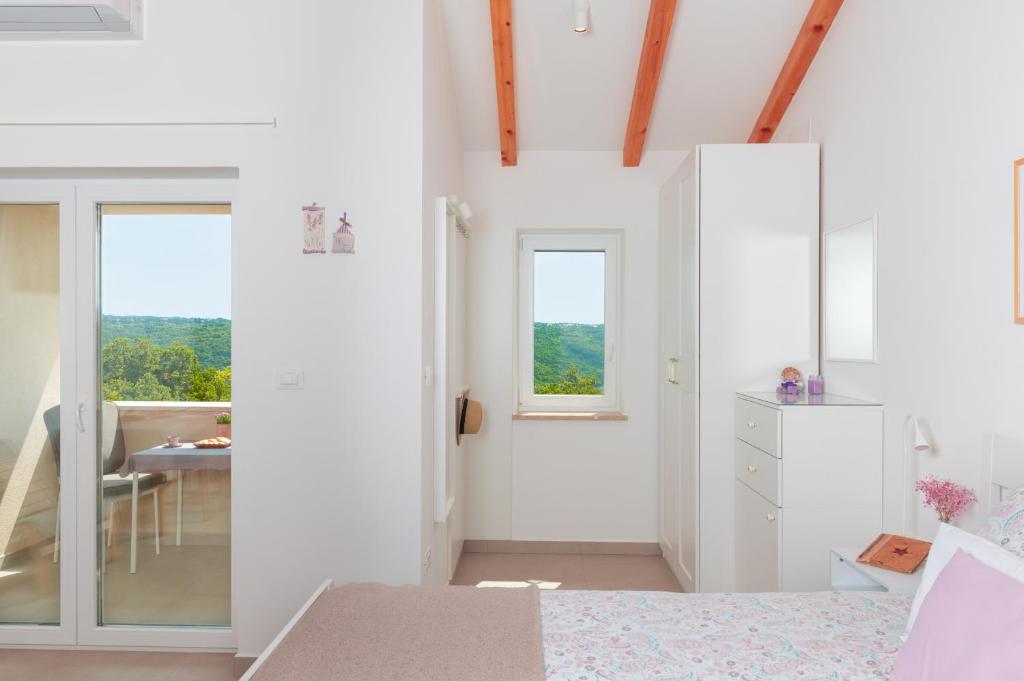 een slaapkamer met witte muren en een bed en een tafel bij Studio LAVANDA - Explore Istrian Riviera and Inland in Tinjan