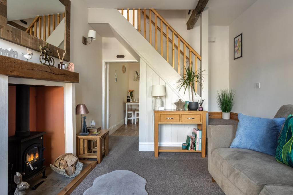 sala de estar con sofá y chimenea en Appleyard Cottage - Yorkshire Dales, en Hellifield