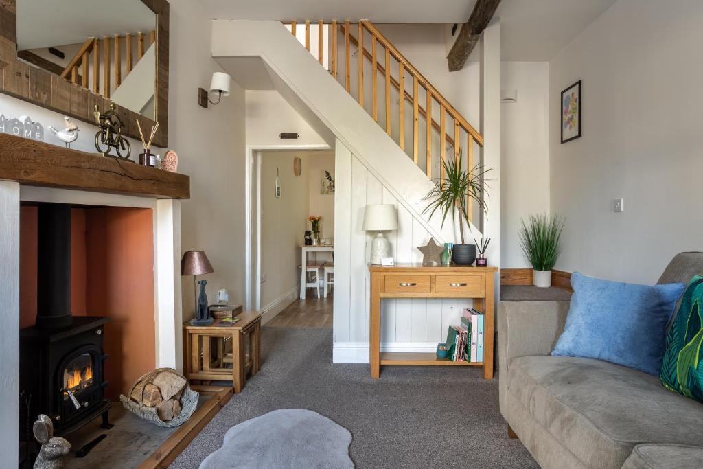 a living room with a couch and a fireplace at Appleyard Cottage - Yorkshire Dales in Hellifield