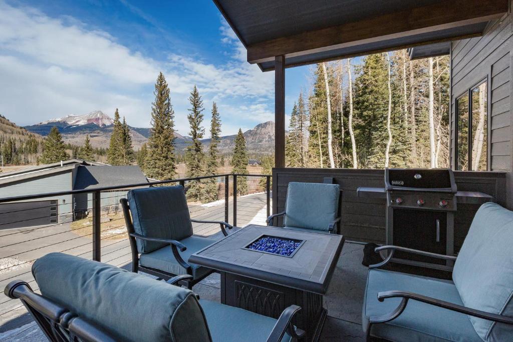 eine abgeschirmte Veranda mit Stühlen, einem Tisch und einem Grill in der Unterkunft Twilight - 126 Tacoma in Durango Mountain Resort