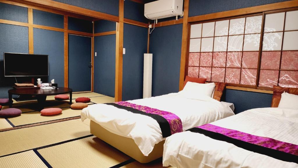 a bedroom with two beds and a tv in it at Annex Kanazawa - Vacation STAY 31114v in Kanazawa