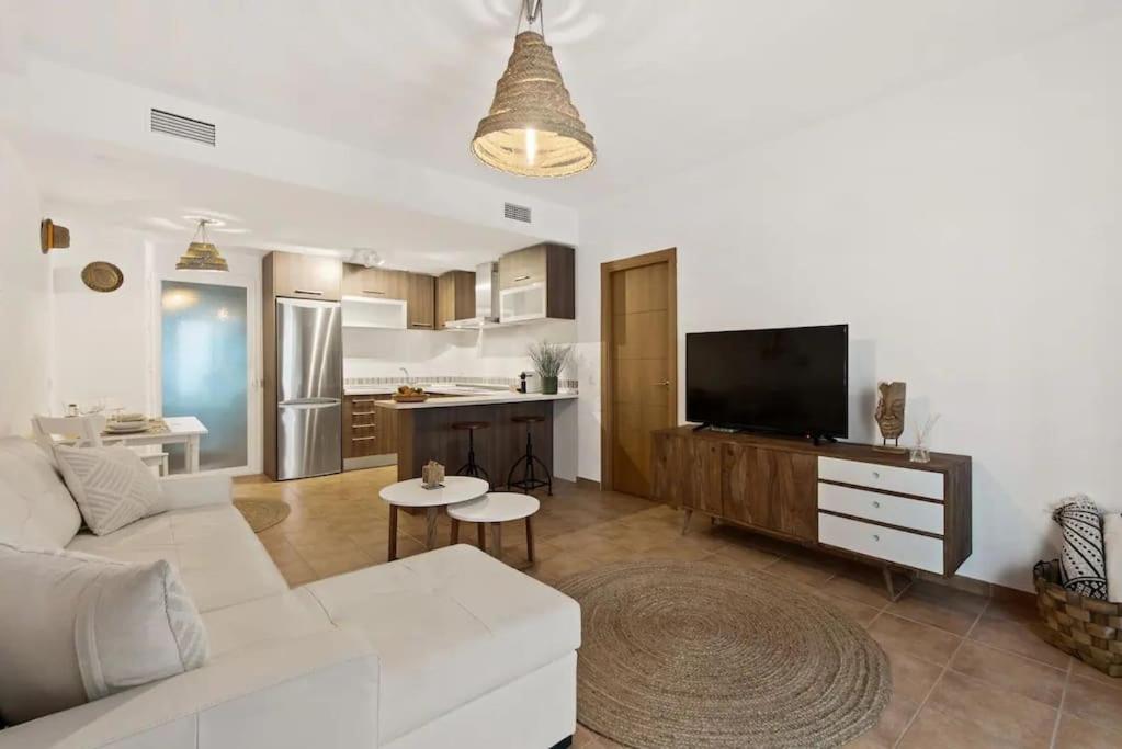 a living room with a white couch and a kitchen at Luxe appartement, centrum Marbella, vlak aan zee! in Marbella