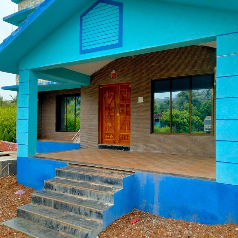 een blauw huis met een trap en een deur bij Shobhnath Home Stay in Harnai