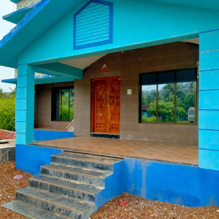 a blue house with stairs and a door at Shobhnath Home Stay in Harnai