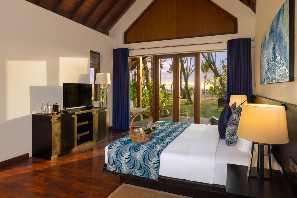 um quarto com uma cama grande e uma televisão em Ayana Sea em Wadduwa