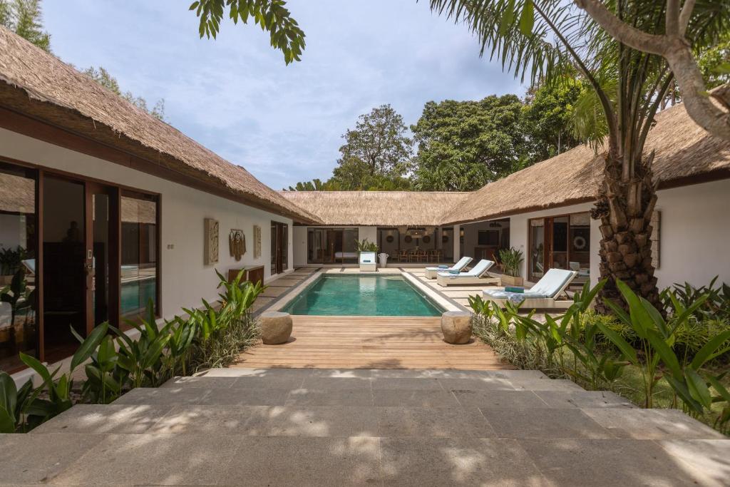 an exterior view of a villa with a swimming pool at Villa Lima Hati in Kerobokan