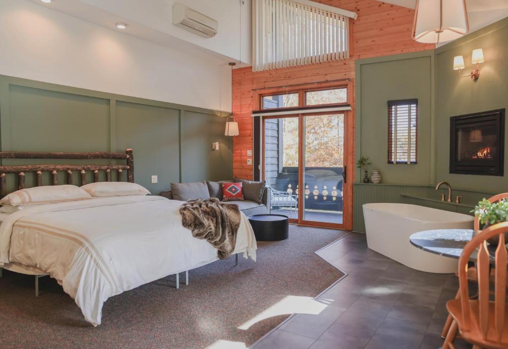 um quarto com uma cama e uma banheira e uma banheira em Outland Chalet & Suites Great Smoky Mountains em Whittier