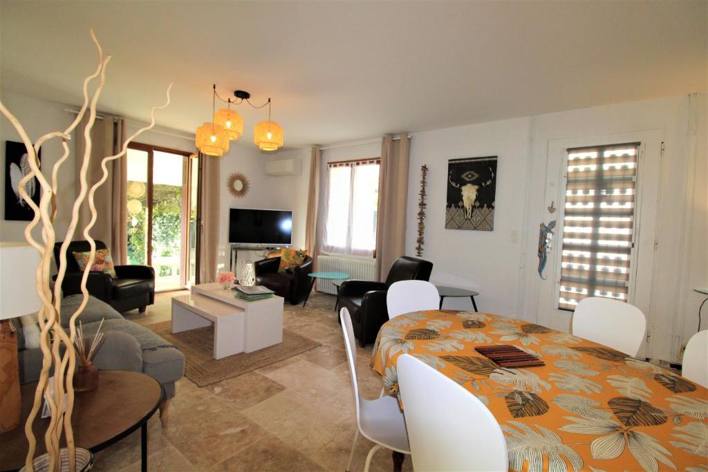 a living room with a dining table and a living room at Les Bastidons de L'Isle - Le Saint-Julien - 3 étoiles in LʼIsle-sur-la-Sorgue