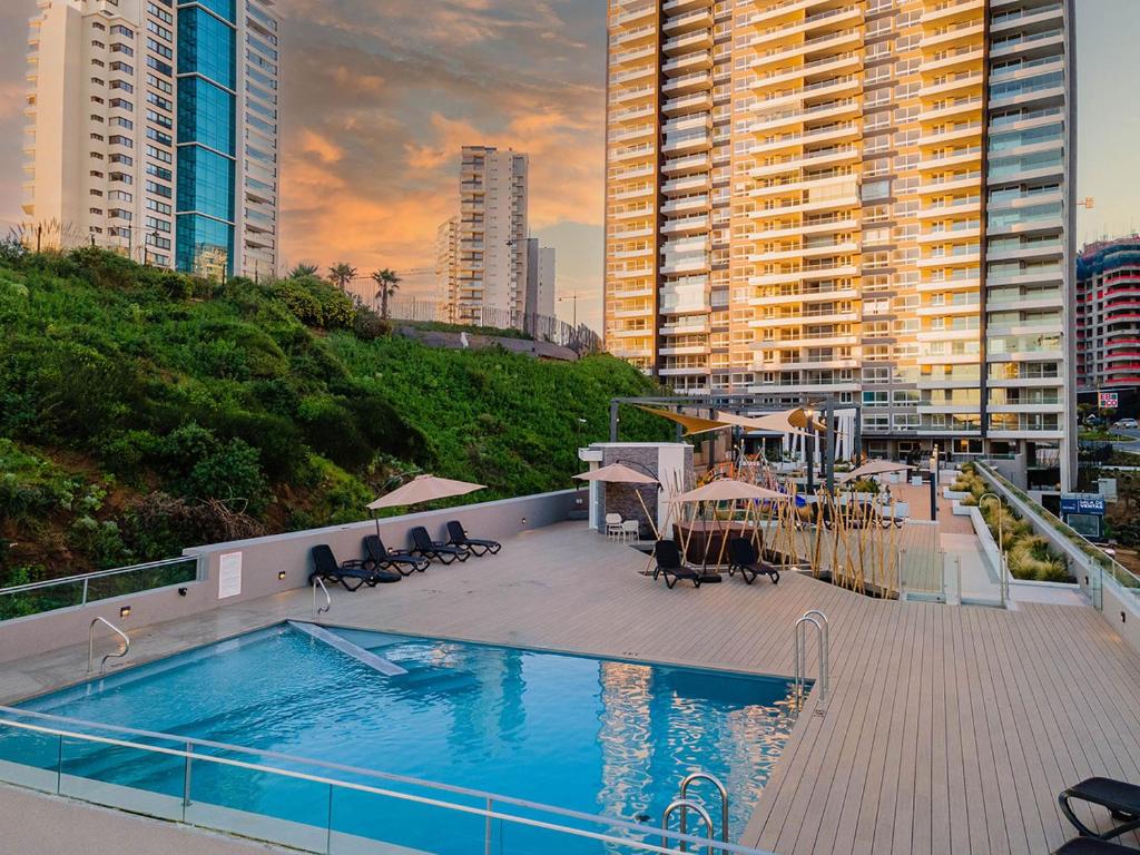 una piscina en la parte superior de un edificio con edificios altos en Costa de Montemar, Concón, Departamento Familiar 2D, 2B, para 6 personas, en Concón